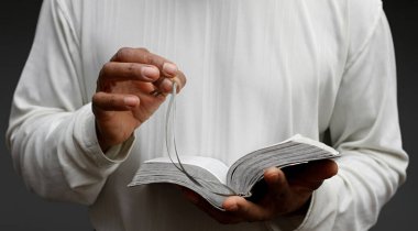 Tanrı 'ya dua eden adam İncil' i tutuyor.