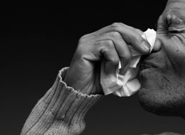 Grip ve nezle olduktan sonra burnu silmek. Gri siyah arka planda, insanların resimli fotoğrafları var.