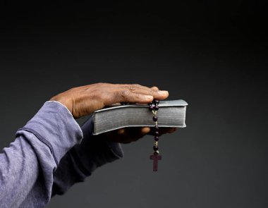 İncil 'i olan Karayipli adam Tanrı' ya dua ediyor.