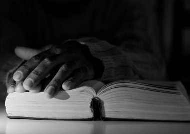 İncil 'i olan Karayipli adam Tanrı' ya dua ediyor.