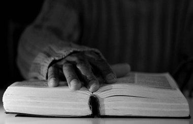 İncil 'i olan Karayipli adam Tanrı' ya dua ediyor.