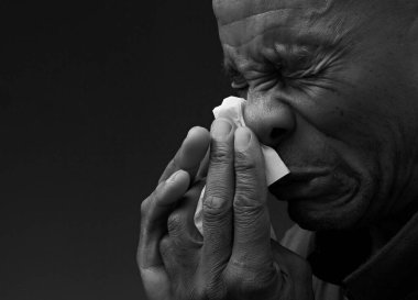 Adam burnunu peçeteyle siliyor. 