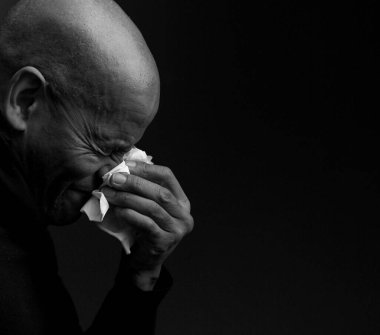 Adam burnunu peçeteyle siliyor. 