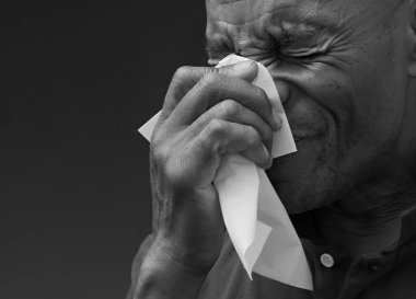 Adam burnunu peçeteyle siliyor. 