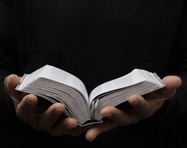 Siyah adam gri arka planda Tanrı 'ya dua ediyor. 