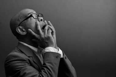 Siyah adam siyah gri arkaplanlı tanrıya dua ediyor.