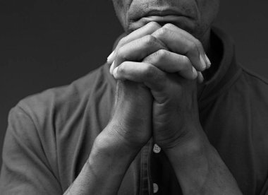 Siyah Karayipli adam siyah arka planda Tanrı 'ya dua ediyor.