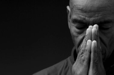 Siyah Karayipli adam siyah arka planda Tanrı 'ya dua ediyor. 