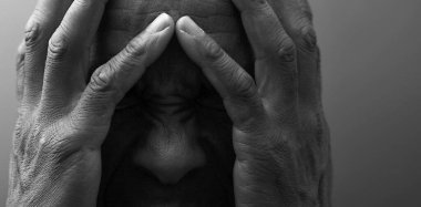 Adam gri siyah arka planda Tanrı 'ya dua ediyor.