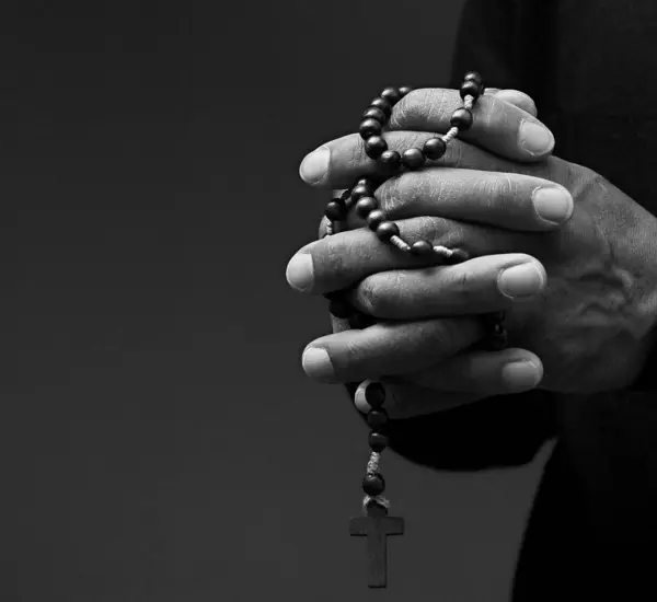 praying to God with hands together on grey black background