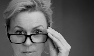 Gri arka planda gözlüklü kadın, stüdyo fotoğrafı.