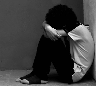 Yoksulluk içinde yerde dua eden çocuk, stüdyo portresi. 