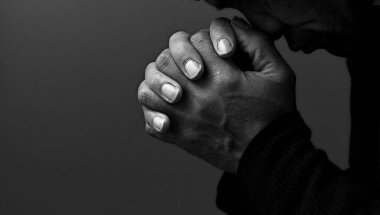 Karayipli adam elleri birarada tanrıya dua ediyor, siyah beyaz stüdyo fotoğrafı.