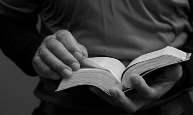 Elinde İncil 'le Tanrı' ya dua eden siyahi bir adam. Karayipli adam siyah arka planda dua ediyor, kırpılmış bölüm