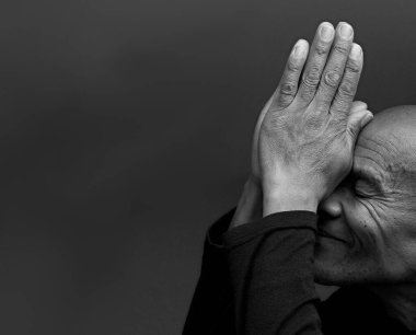 Karayipli adam elleri birarada tanrıya dua ediyor, siyah beyaz stüdyo fotoğrafı.