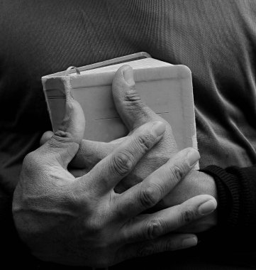 Elinde İncil 'le Tanrı' ya dua eden siyahi bir adam. Karayipli adam siyah arka planda dua ediyor, kırpılmış bölüm