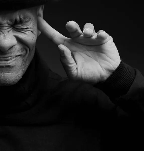 Deaf man suffering from deafness and hearing loss. Black and white image