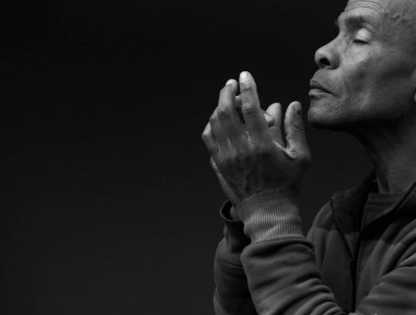 Siyah arka planda dua eden bir adam.  