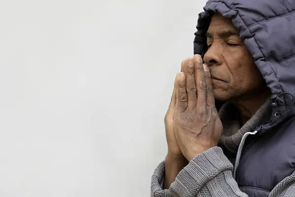 Man in hood praying to god with hands on white background
