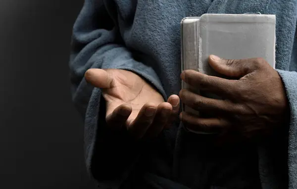 Man praying to god with bible in the hands, close up