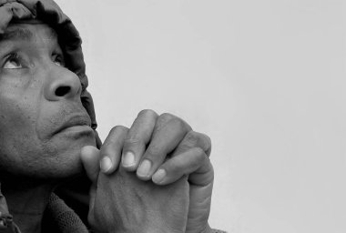 Adam elleri gri arka planda Tanrı 'ya dua ediyor.  