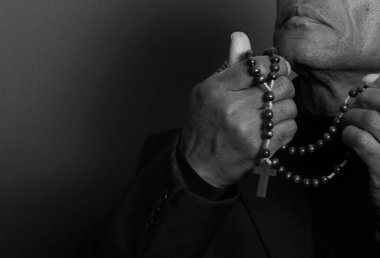 Tanrı 'ya dua eden bir adam. Elinde tespihle.
