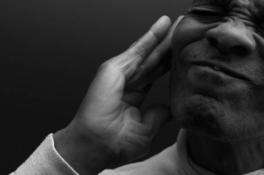 Sağır adam gri arka planda sağırlık ve işitme kaybı yaşıyor 