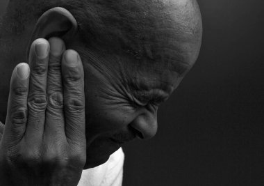 Sağır adam gri arka planda sağırlık ve işitme kaybı yaşıyor 