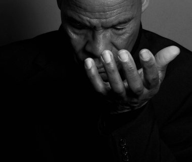 Adam karanlık arka planda Tanrı 'ya dua ediyor