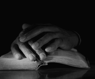 Tanrı 'ya dua eden adam İncil' in üzerinde.