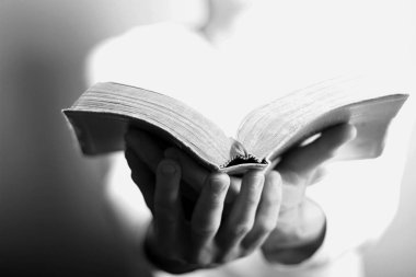 İncil 'i elinde tutan dua eden adamın kesilmiş bölümü.