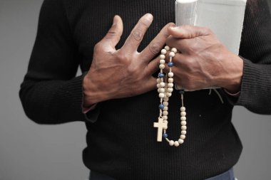 İncil 'i elinde tutan dua eden adamın kesilmiş bölümü.