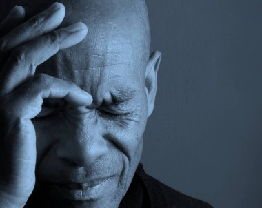 Baş ağrısı çeken yaşlı Afrikalı bir adamın portresi.