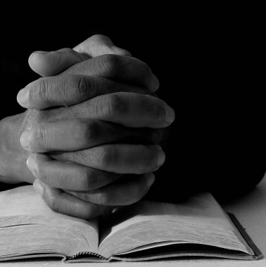 İncilin üstünde dua eden bir adam 