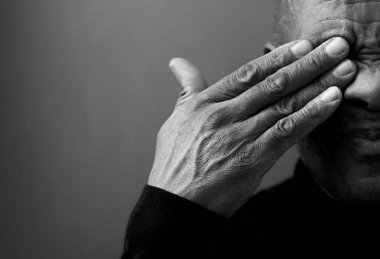 Gözünü kapatan üzgün bir adamın siyah beyaz portresi. 