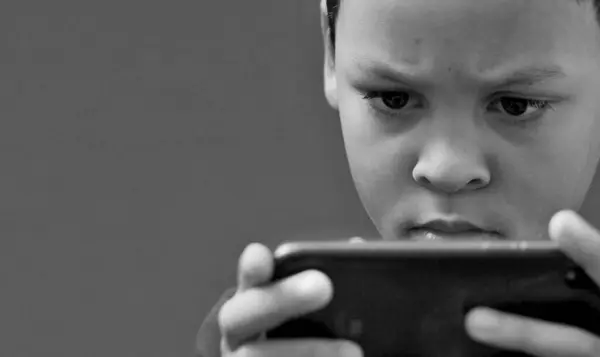 Akıllı telefon kullanan bir çocuk, stüdyo fotoğrafı.