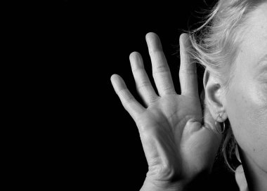 Gri arka planda sağırlık ve işitme kaybı yaşayan bir kadın. 