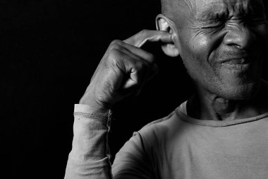 Afrikalı adam parmaklarıyla kulaklarını kapatıyor, stüdyo çekimi.