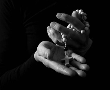 Siyah arka plan üzerinde haç tutan eller, siyah ve beyaz 