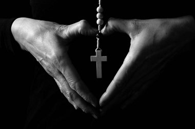 Eller kalbi şekillendirir ve siyah arkaplan üzerinde çapraz tutar, siyah ve beyaz 