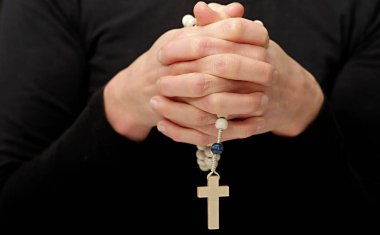 İnsanın orta kesimi namaz kılıyor, siyah arka plan üzerinde kesişiyor.