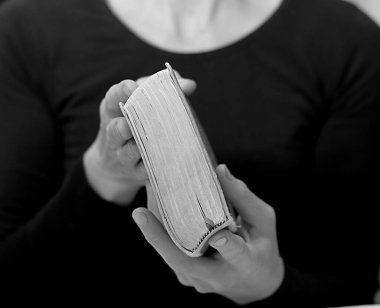 İncil 'i tutan kadının orta bölümü, siyah ve beyaz. 