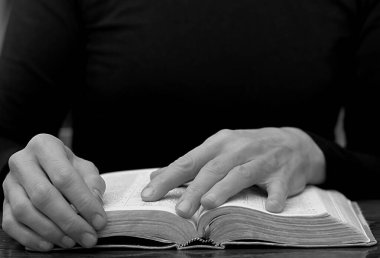 Masada İncil okuyan bir adamın orta bölümü, siyah beyaz.  