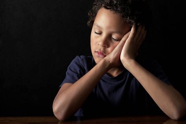 Yorgun küçük çocuk sınıfta uyuyakalmış.