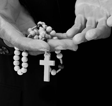 Siyah arka plan üzerinde haç tutan eller, siyah ve beyaz 