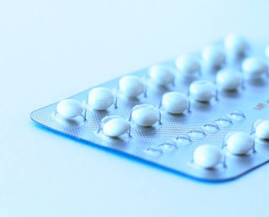 Beyaz arka planda doğum kontrol hapları