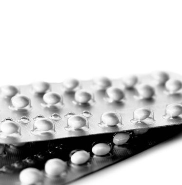 Beyaz arka planda iki paket doğum kontrol hapı.