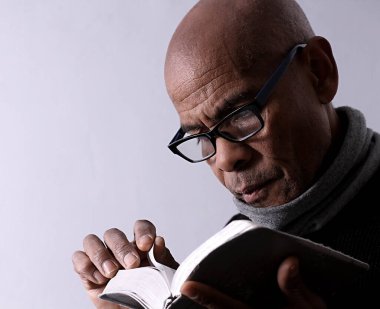 Afrikalı Amerikalı adam İncil okuyor. 