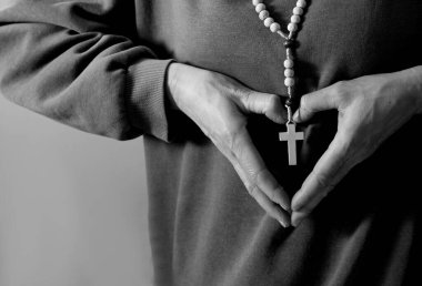 Tespihi olan adam kalp hareketi yapıyor.