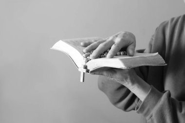 Kadın tespih ve incil ile dua ediyor.